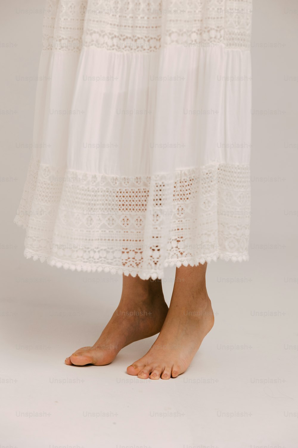 uma mulher que veste um vestido branco e sandálias