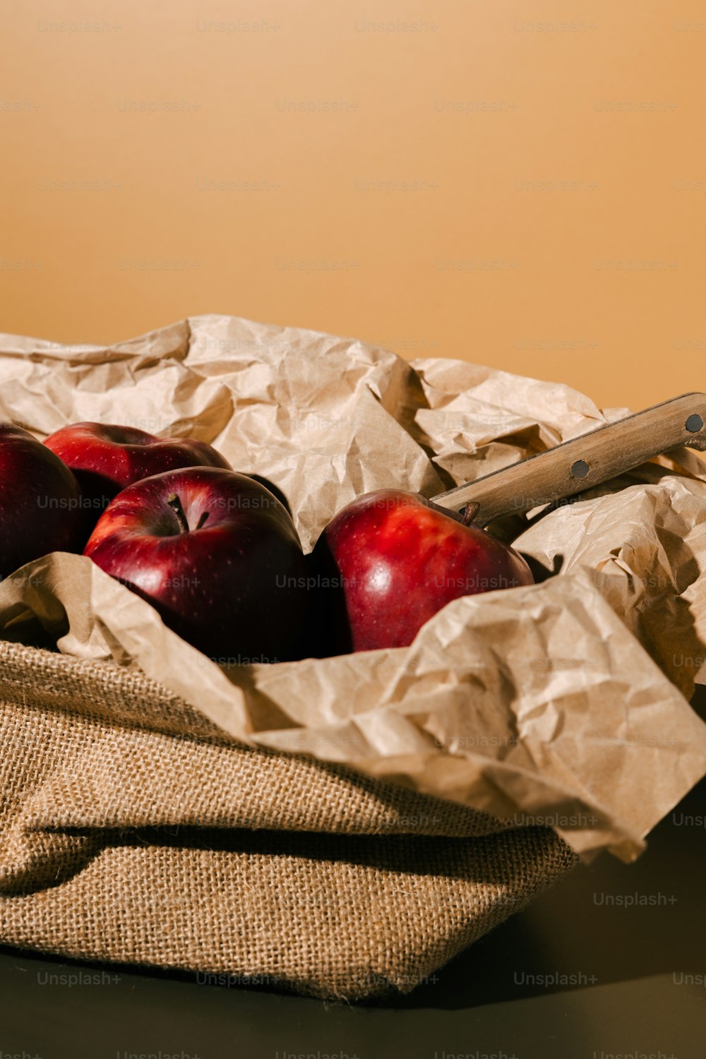uma cesta de maçãs sentada em cima de uma mesa