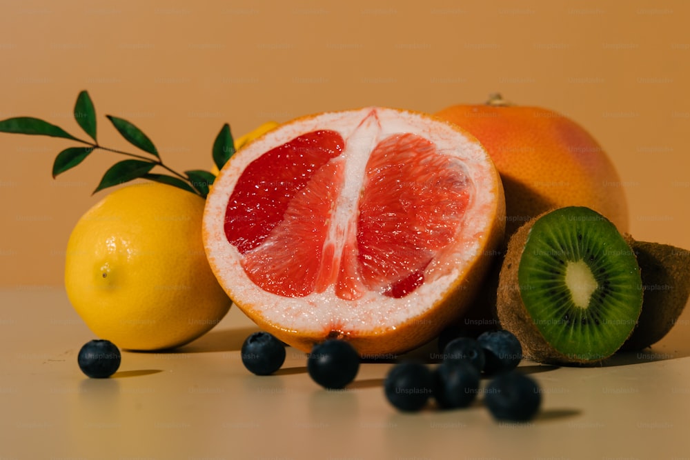 a grapefruit, kiwi, lemon, and blueberries on a table