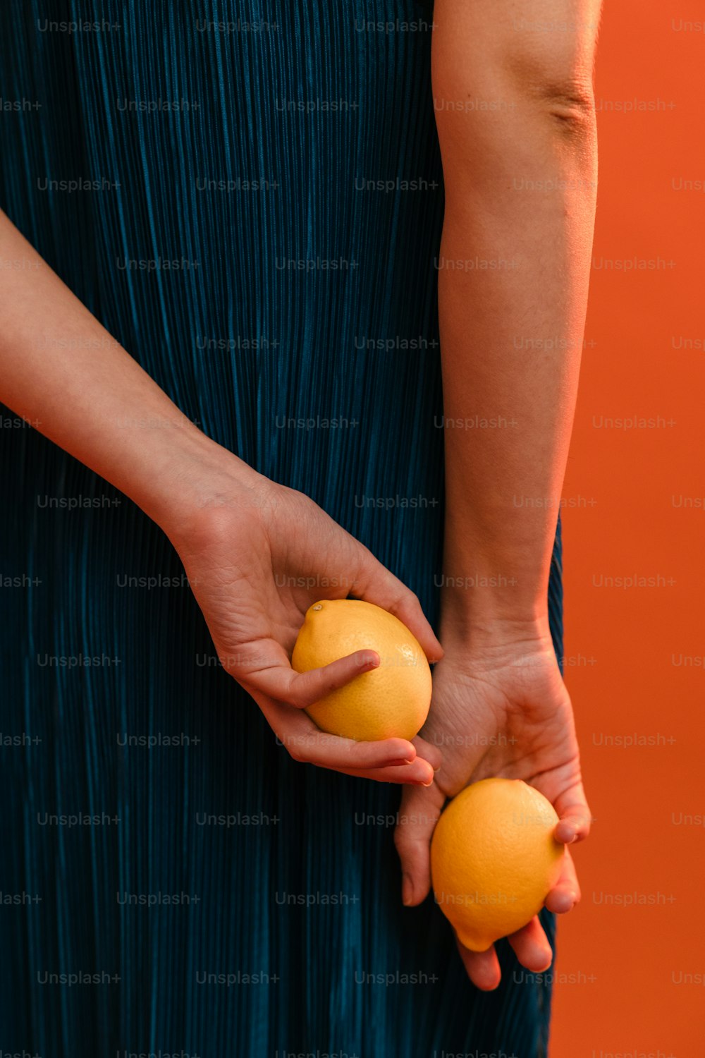 オレンジを2つ手に持つ女性