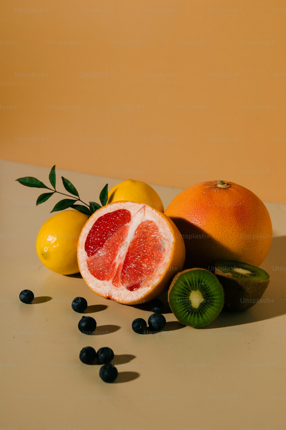 un pompelmo, arancia, kiwi e limoni su un tavolo