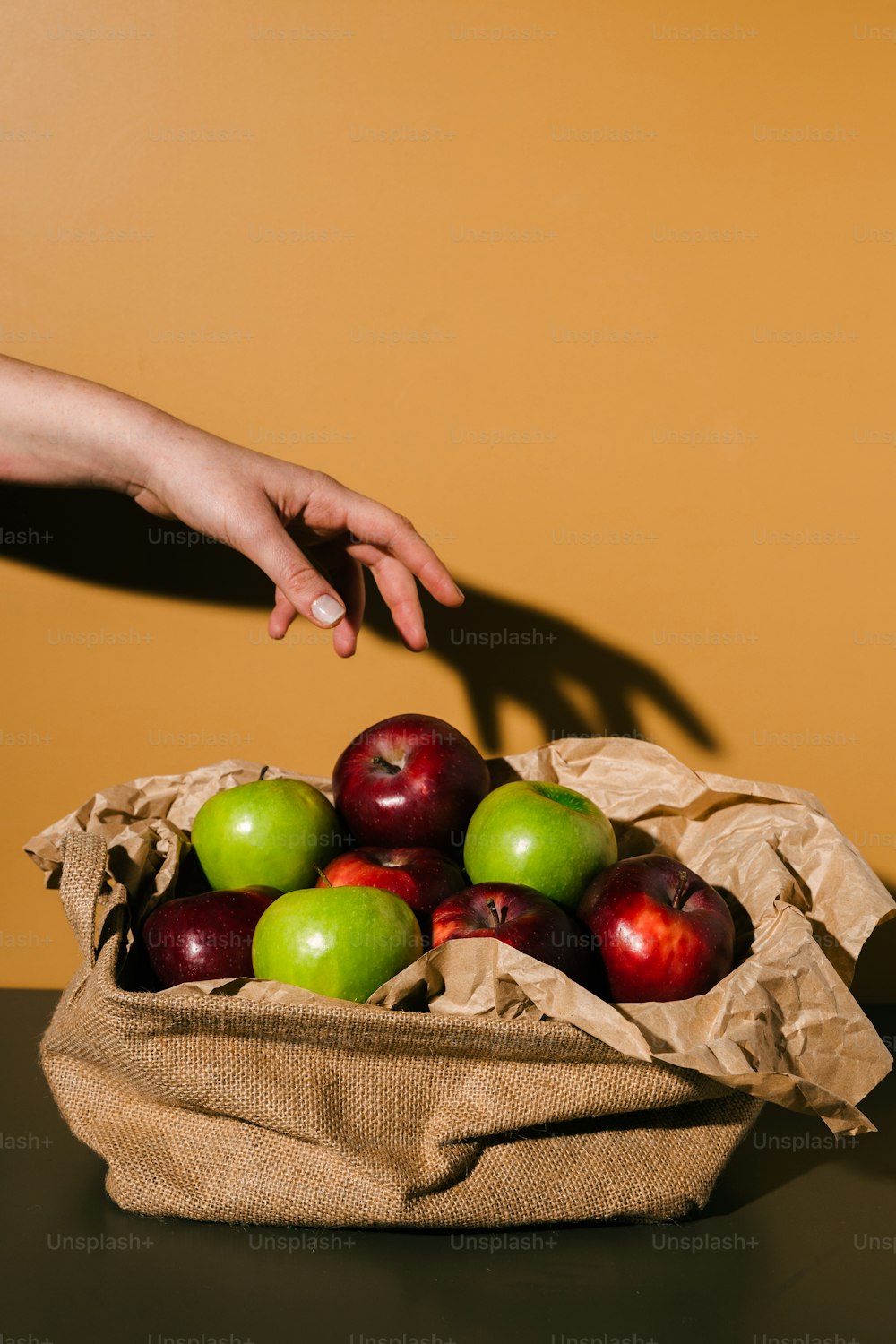 袋の中のリンゴに手を伸ばす人