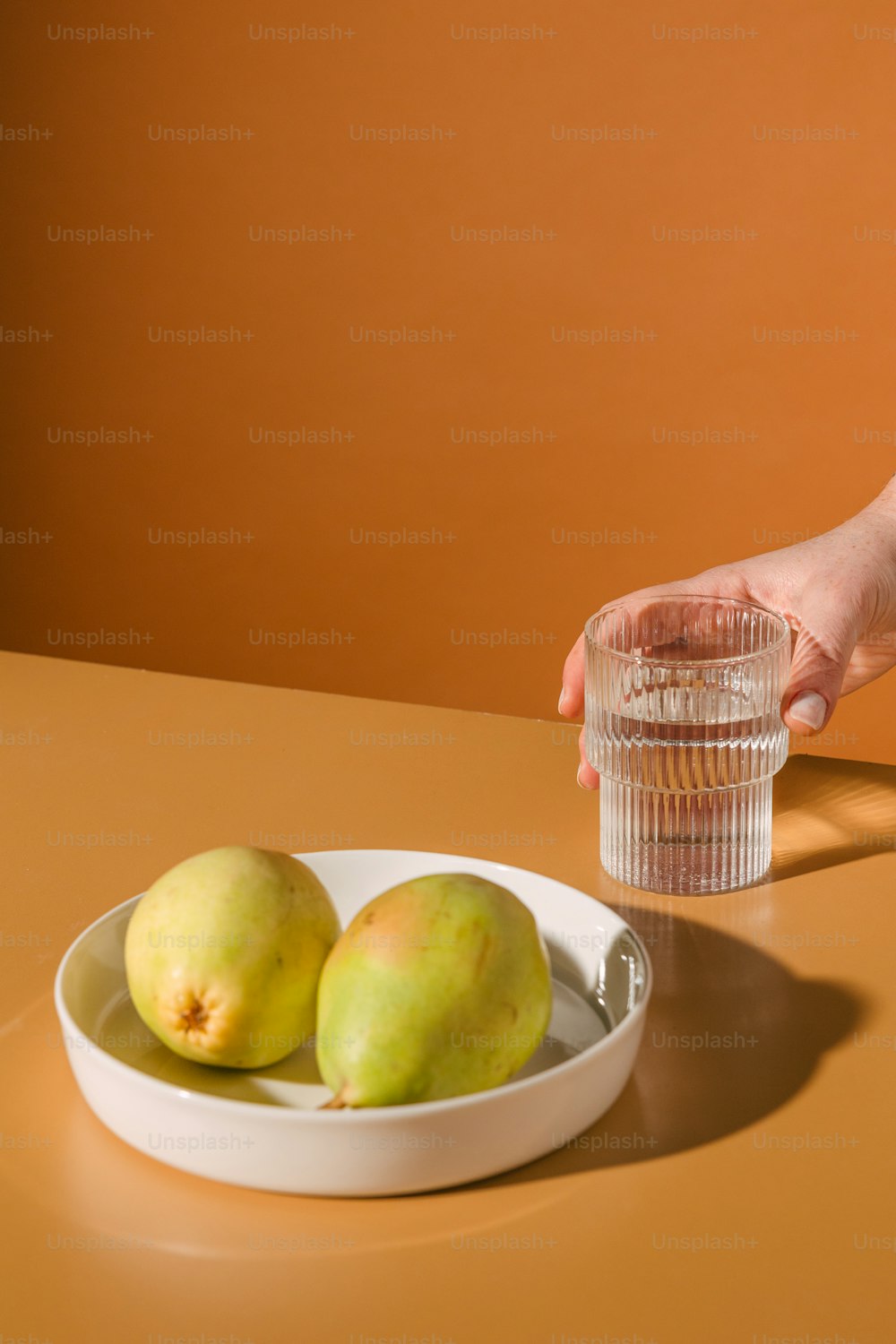 uma tigela de frutas e um copo de água em uma mesa