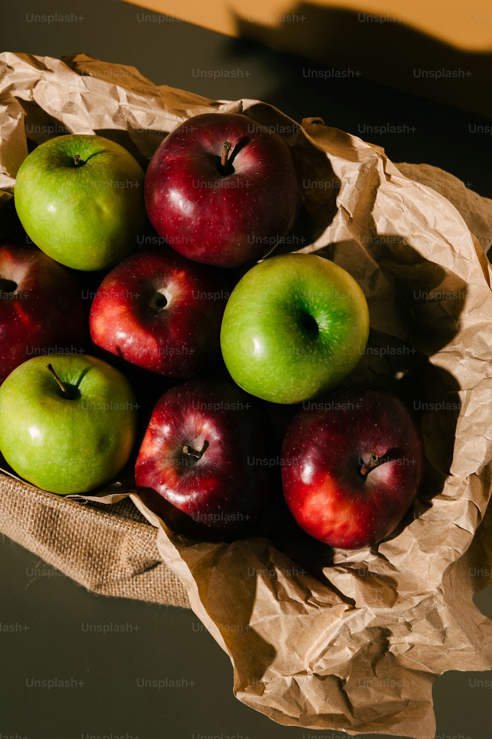 a paper bag filled with red and green apples