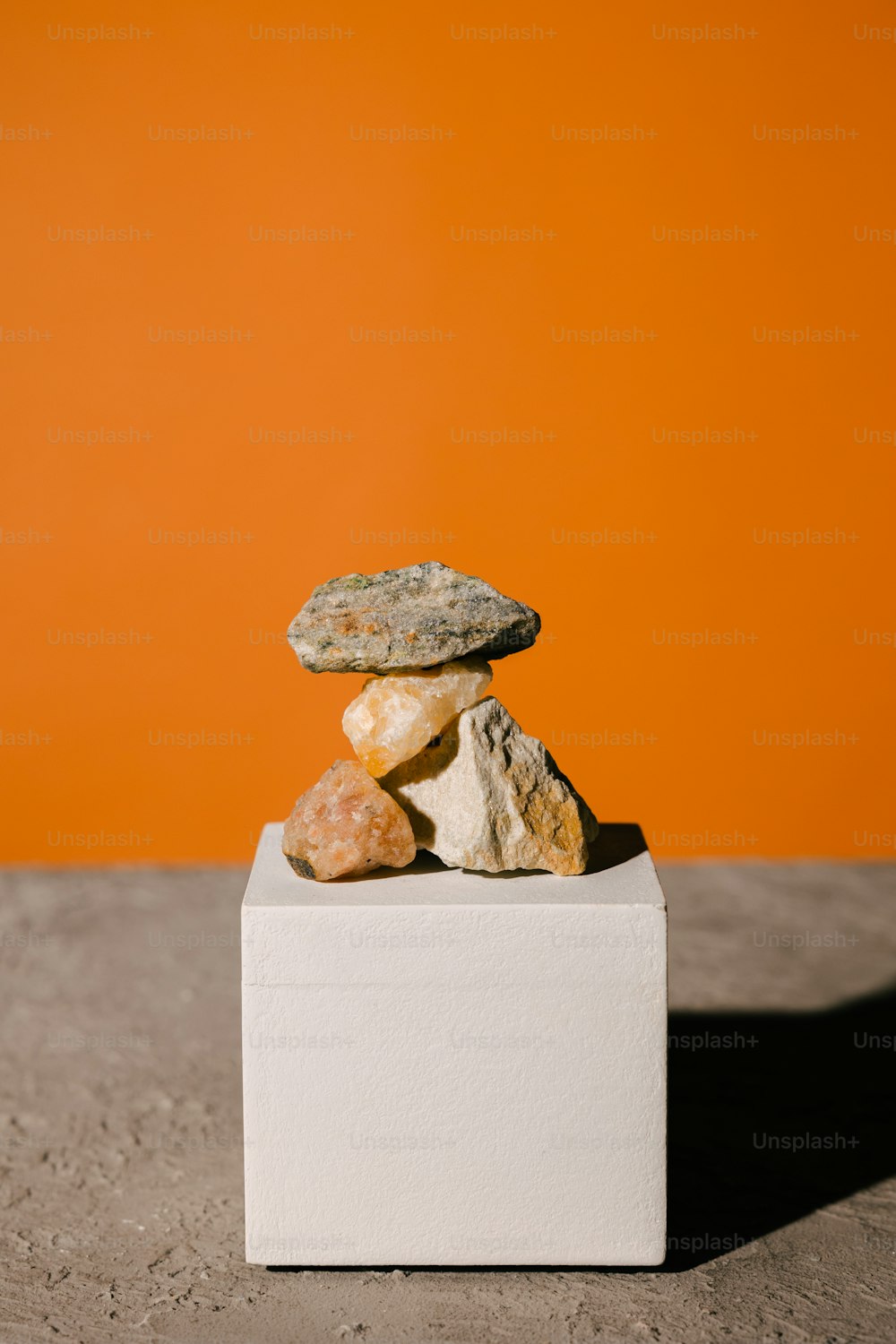 a stack of rocks sitting on top of a white block