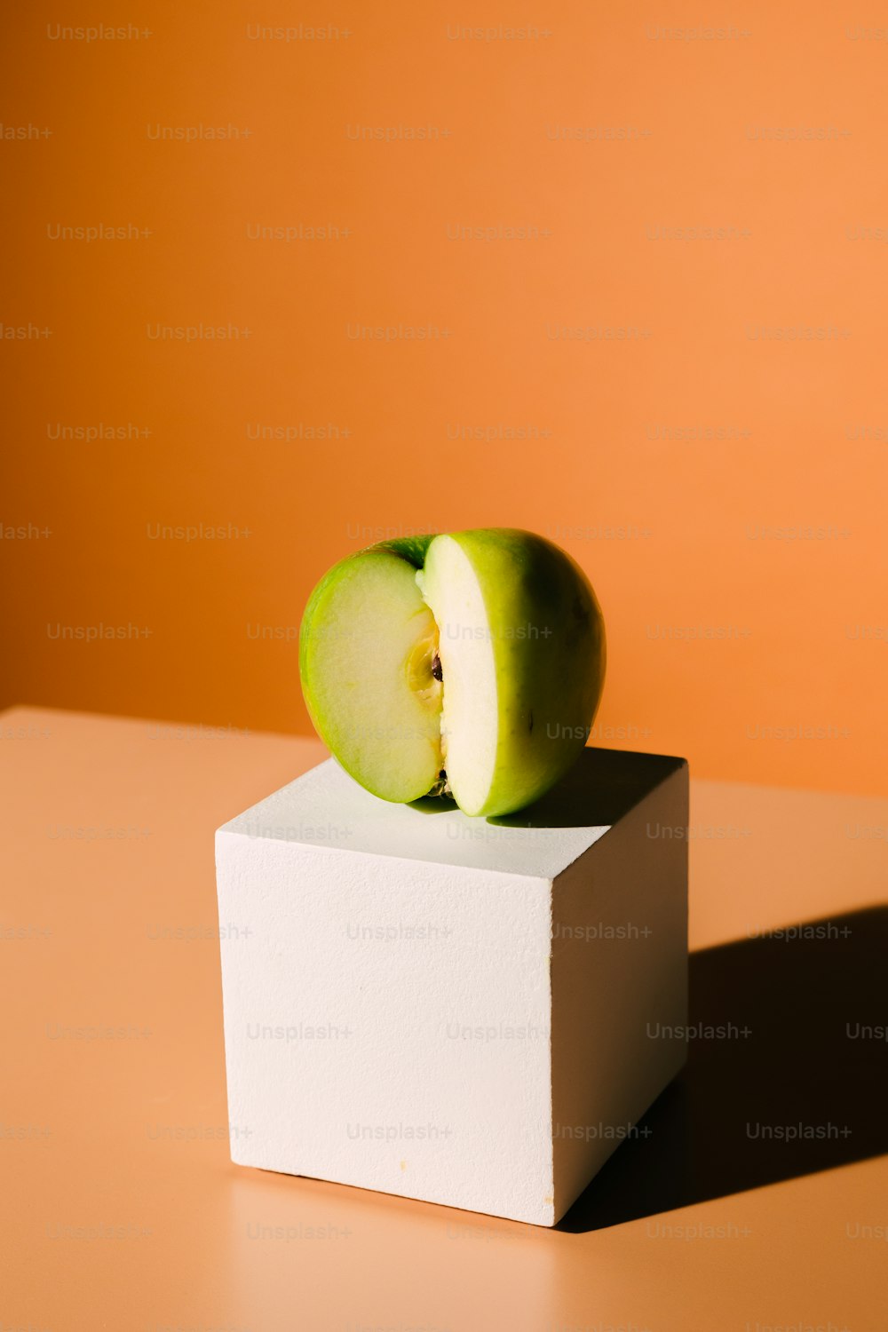 하얀 상자 위에 앉아 있는 녹색 사과