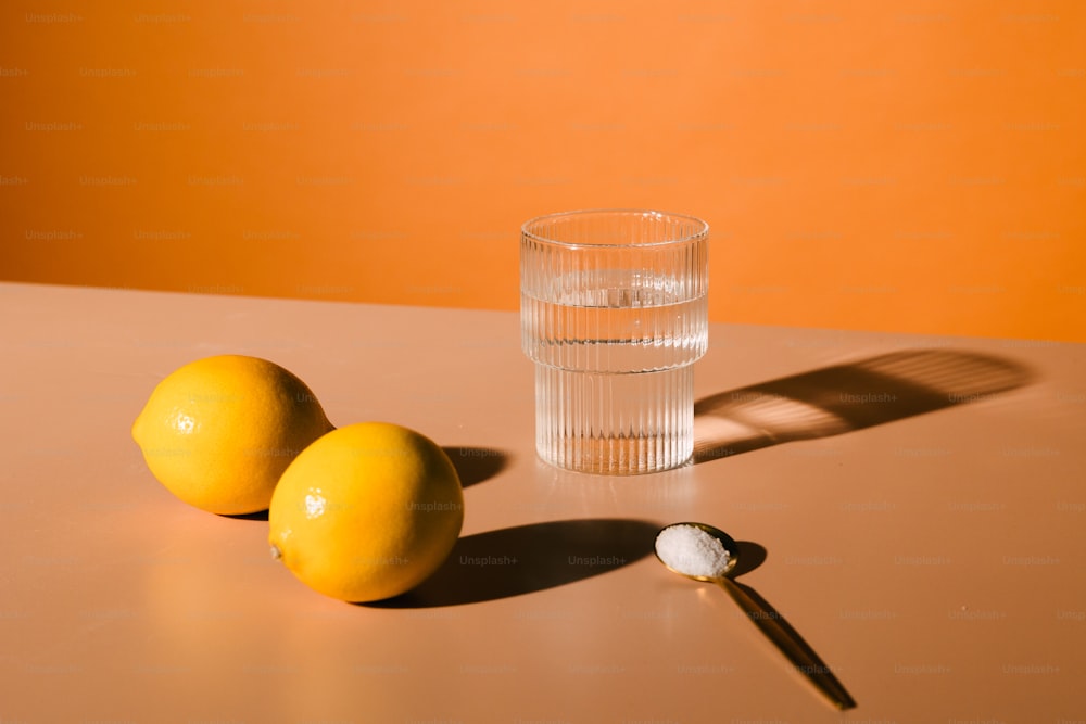 테이블에 레몬 두 개와 물 한 잔