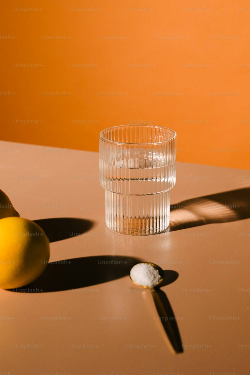 Zwei Zitronen und ein Glas auf einem Tisch