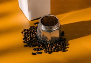 un frasco lleno de granos de café junto a una caja