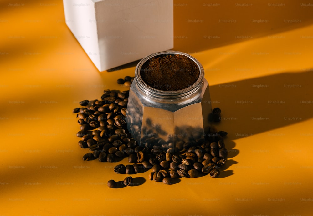 a jar filled with coffee beans next to a box