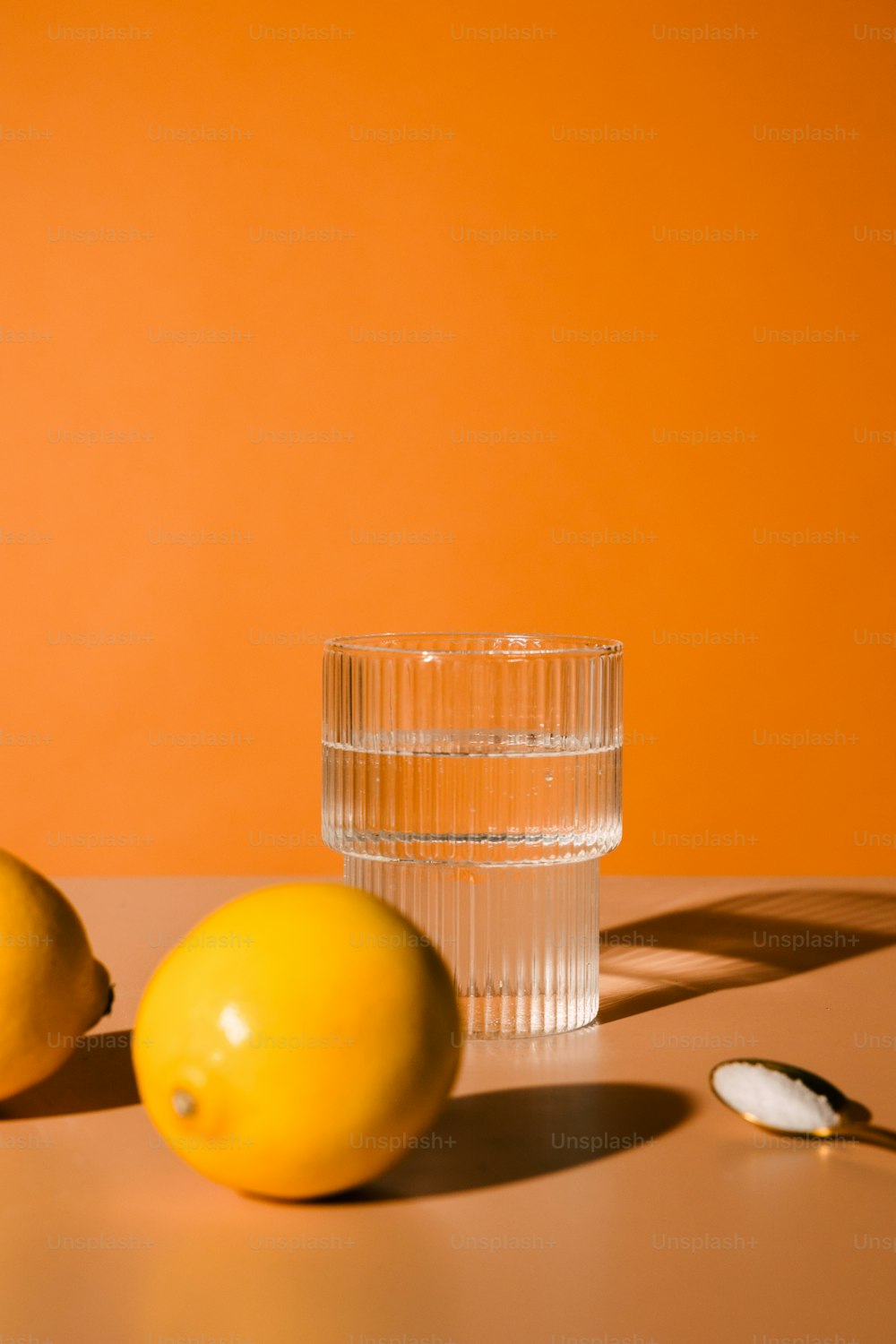 a glass of water and two lemons on a table
