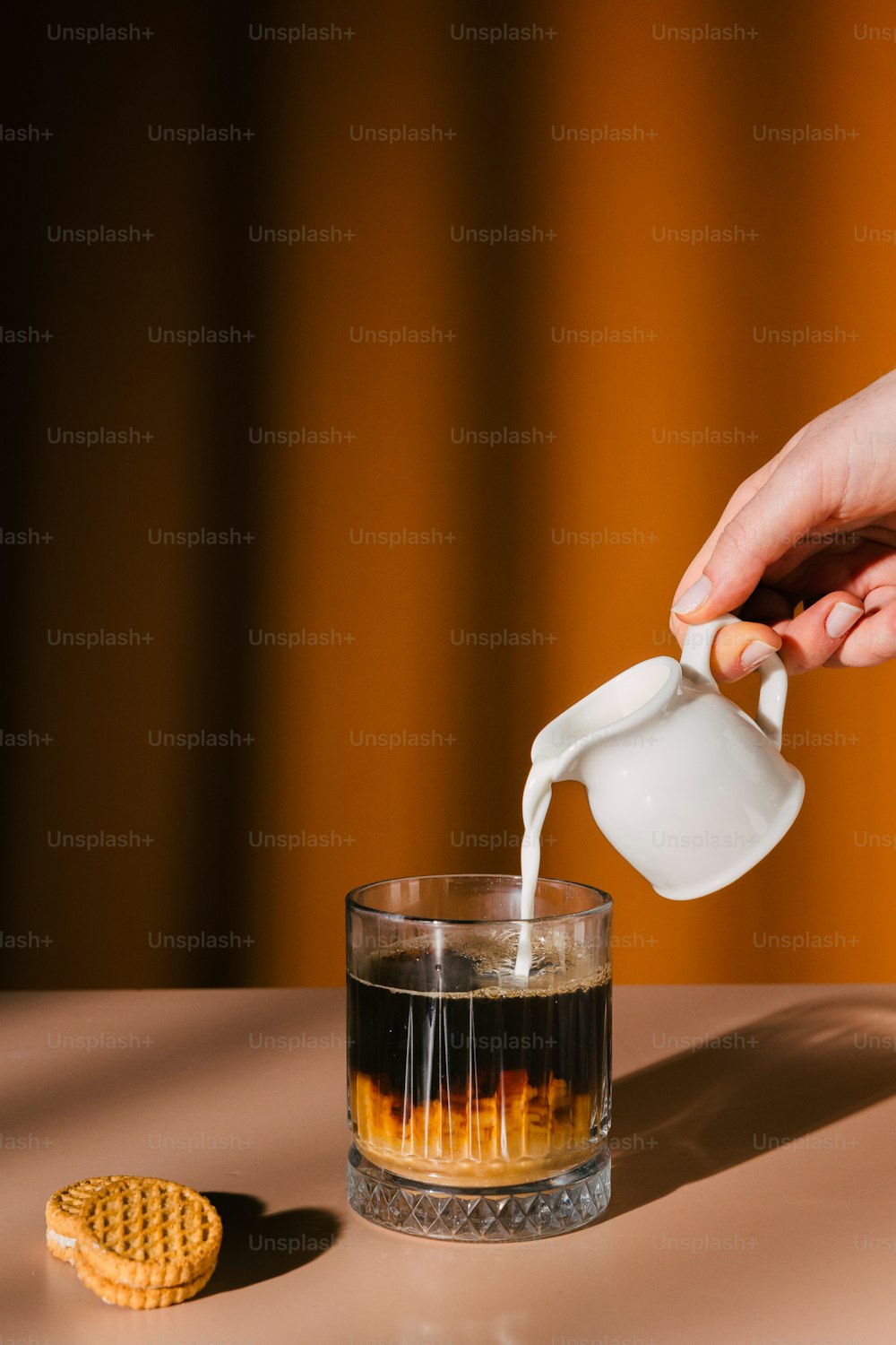 a person pouring a drink into a glass