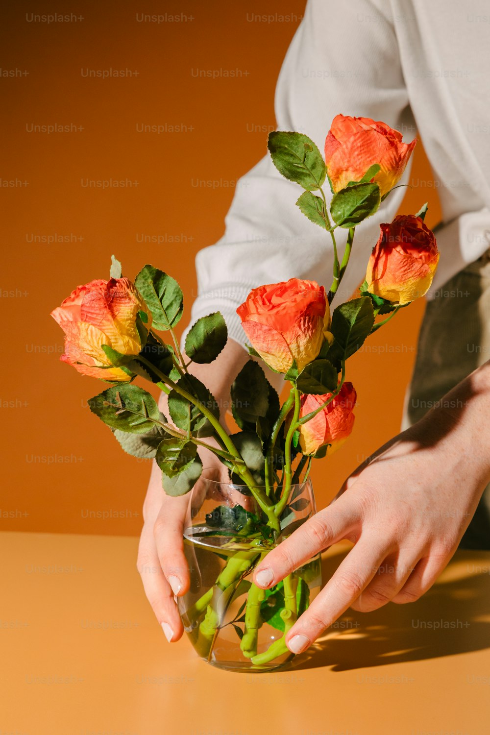 eine Person, die eine Vase mit Blumen darin hält