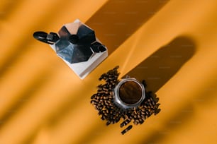 a cup of coffee next to a grinder and coffee beans