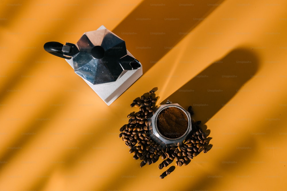 a cup of coffee next to a grinder and coffee beans