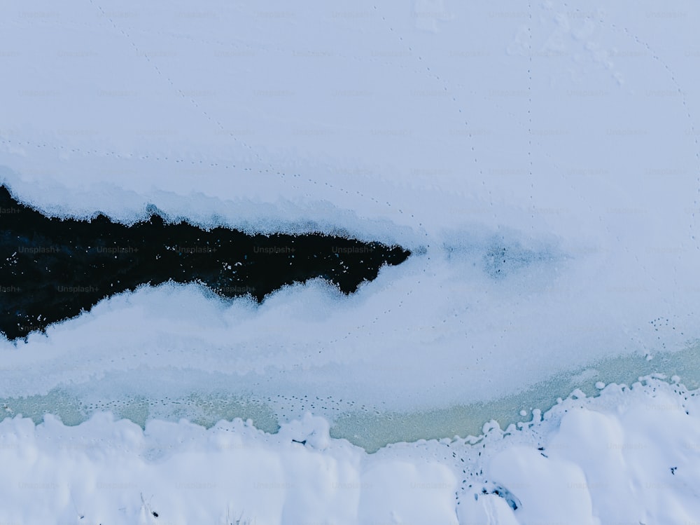 a black and white photo of snow and water