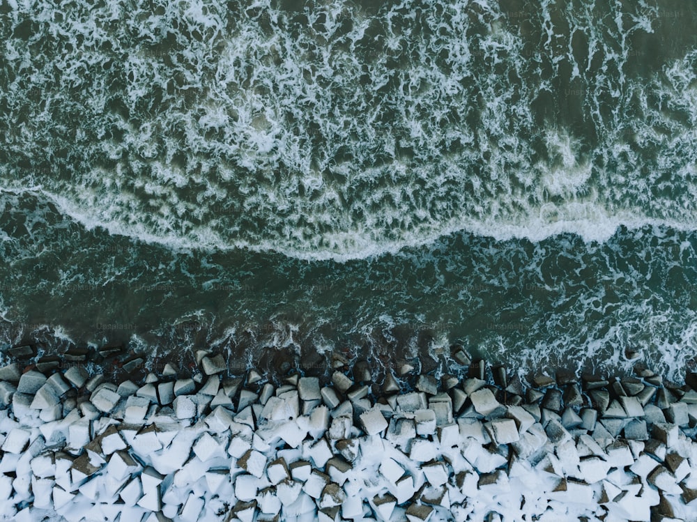uma vista aérea de uma praia rochosa e oceano
