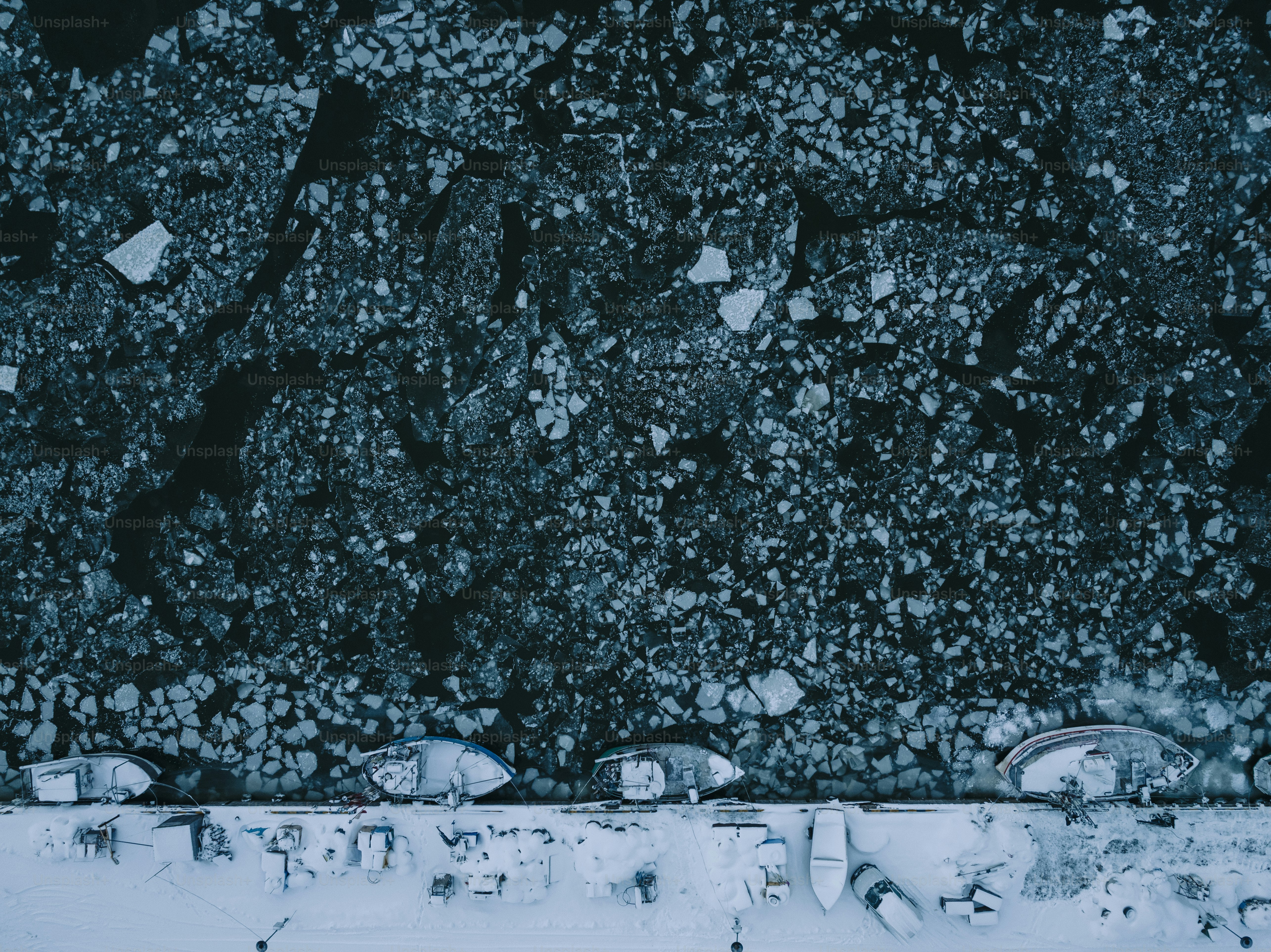 a group of snowboarders sitting on top of a snow covered slope