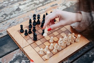 a person playing a game of chess on a wooden board