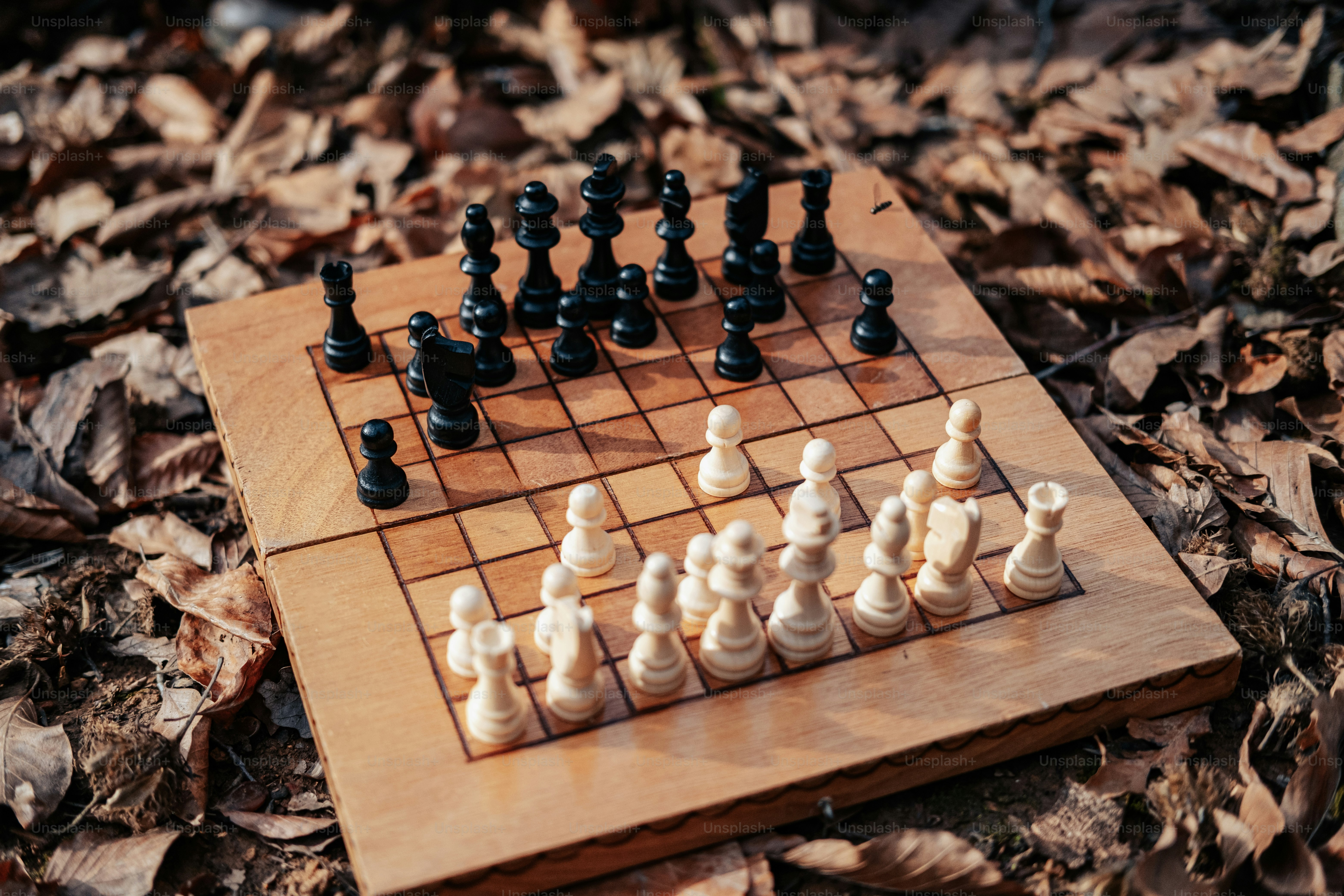 a wooden chess board with black and white pieces