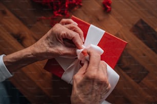 a person wrapping a red and white present