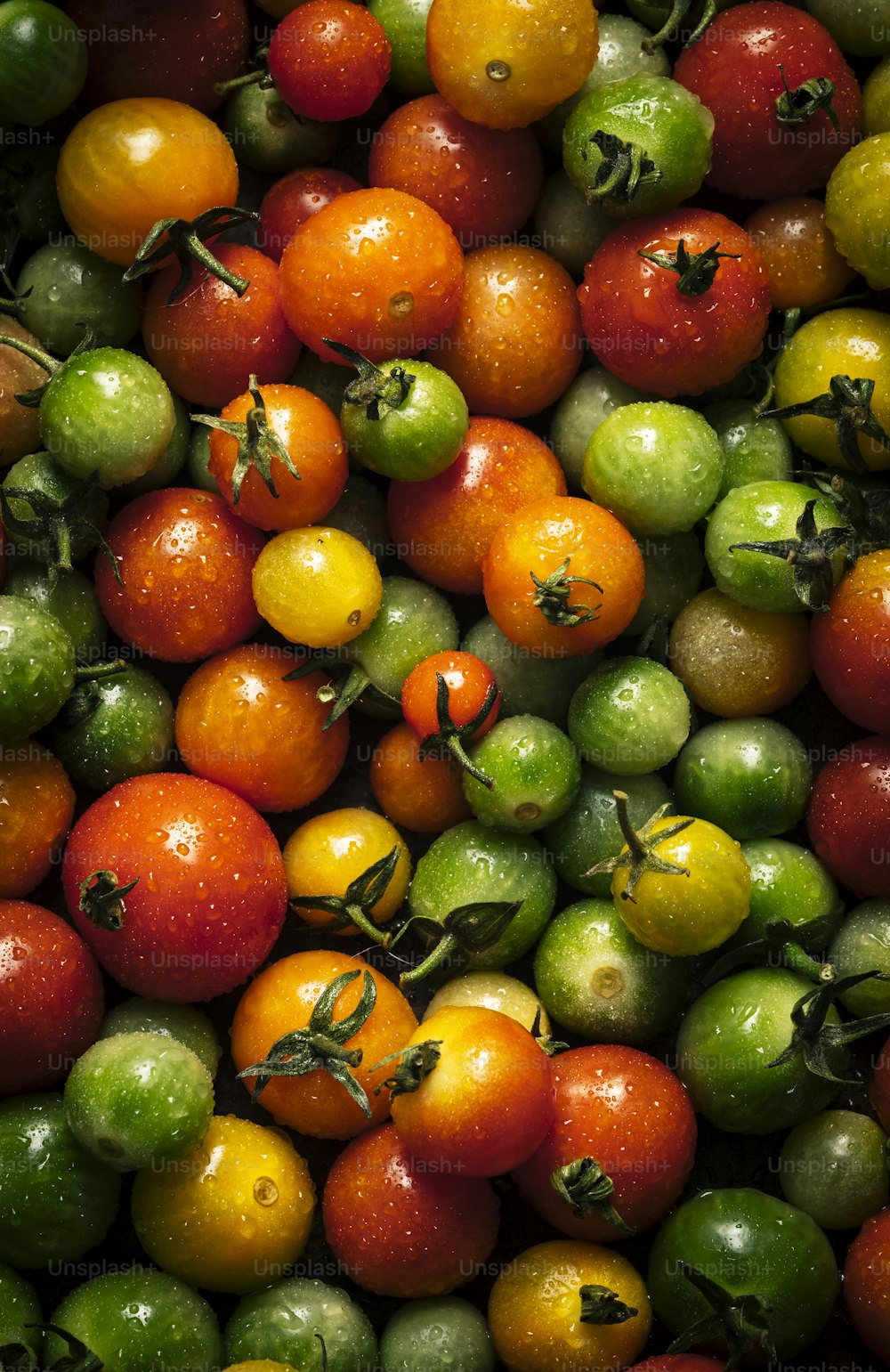 a large pile of tomatoes and other fruits