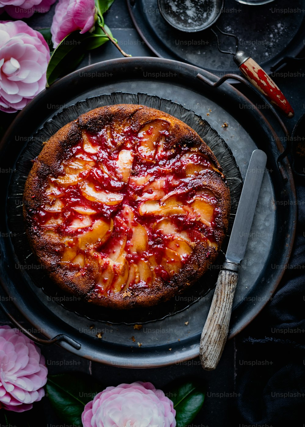 un gâteau sur une assiette avec des fleurs autour