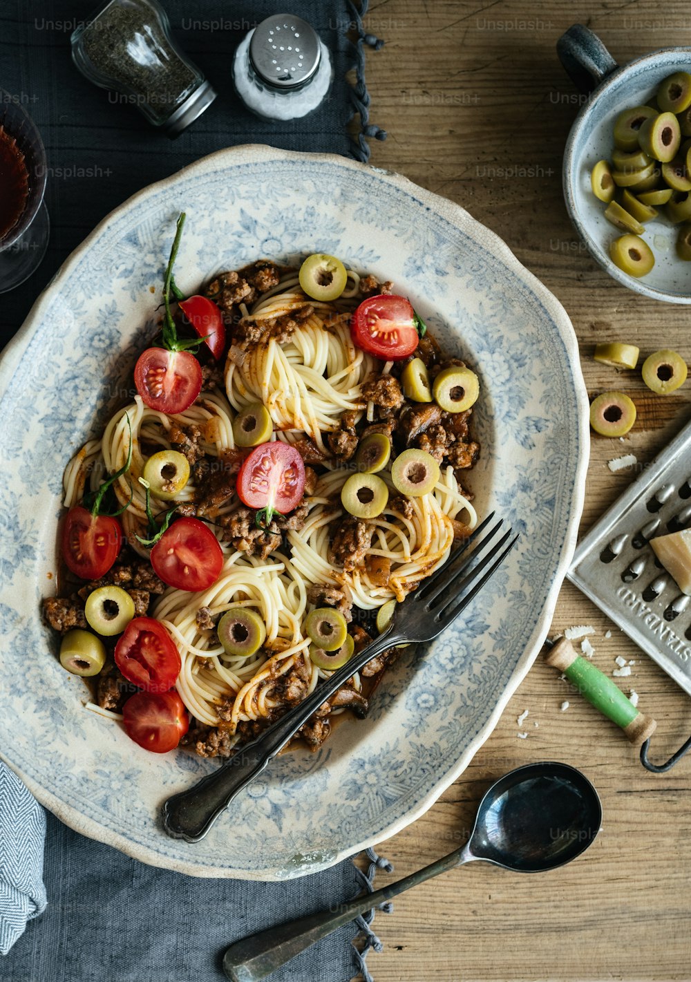 une assiette de pâtes avec des olives et des tomates