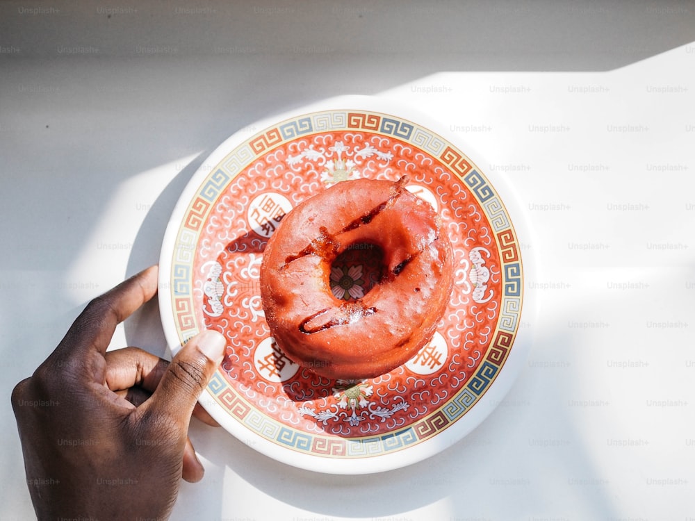 uma pessoa segurando um prato com um donut sobre ele