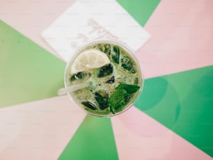 un verre avec de la glace et du citron vert sur une table