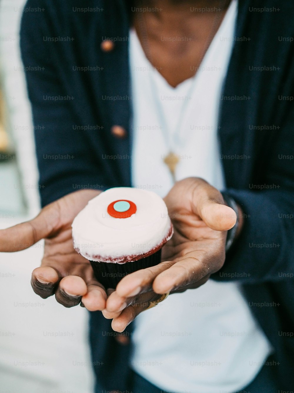 a person holding a cupcake in their hands