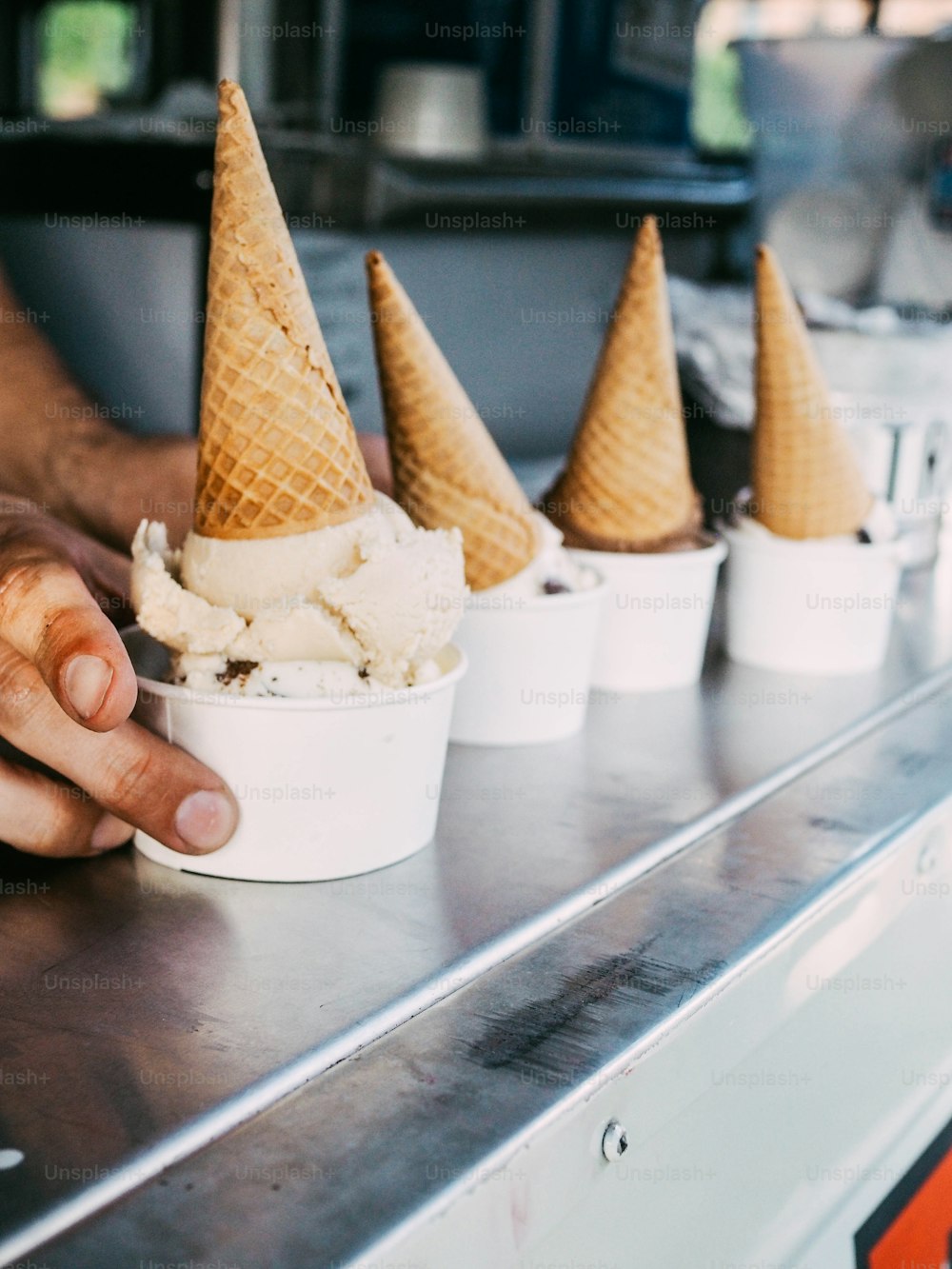 a hand reaching for an ice cream cone