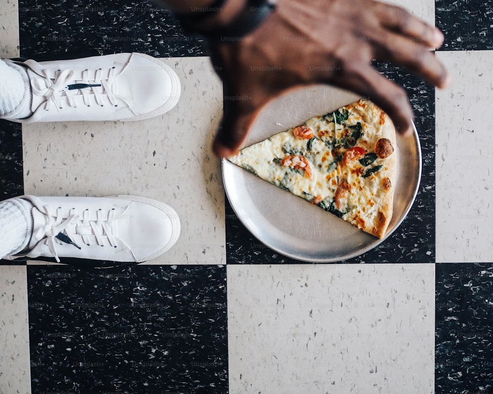 a slice of pizza on a plate on a checkered floor