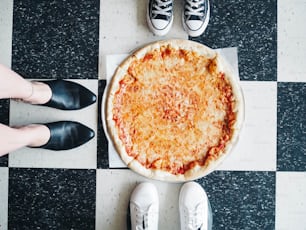 eine Pizza auf einem schwarz-weiß karierten Boden