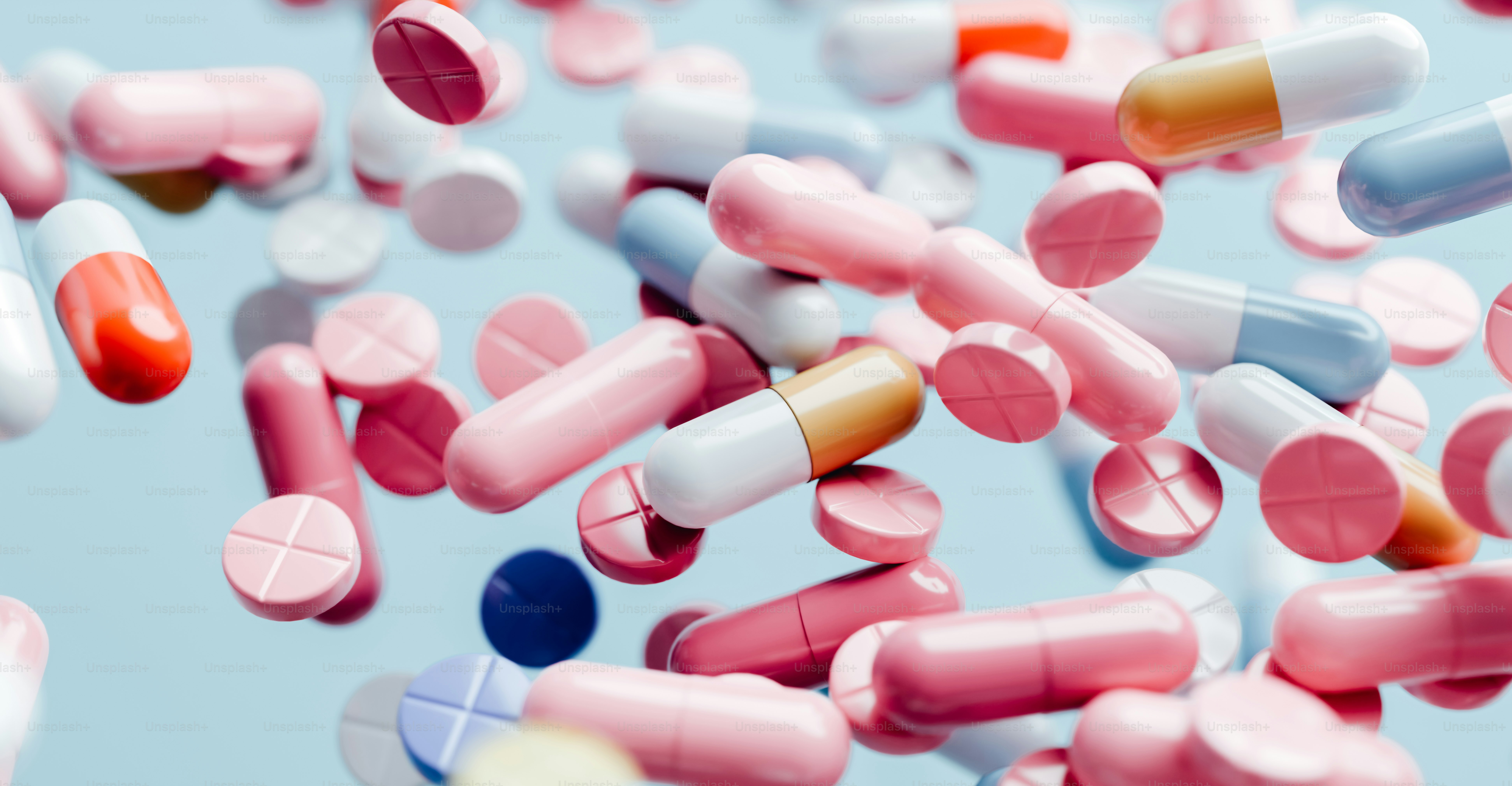 a bunch of pink and white pills scattered on top of each other