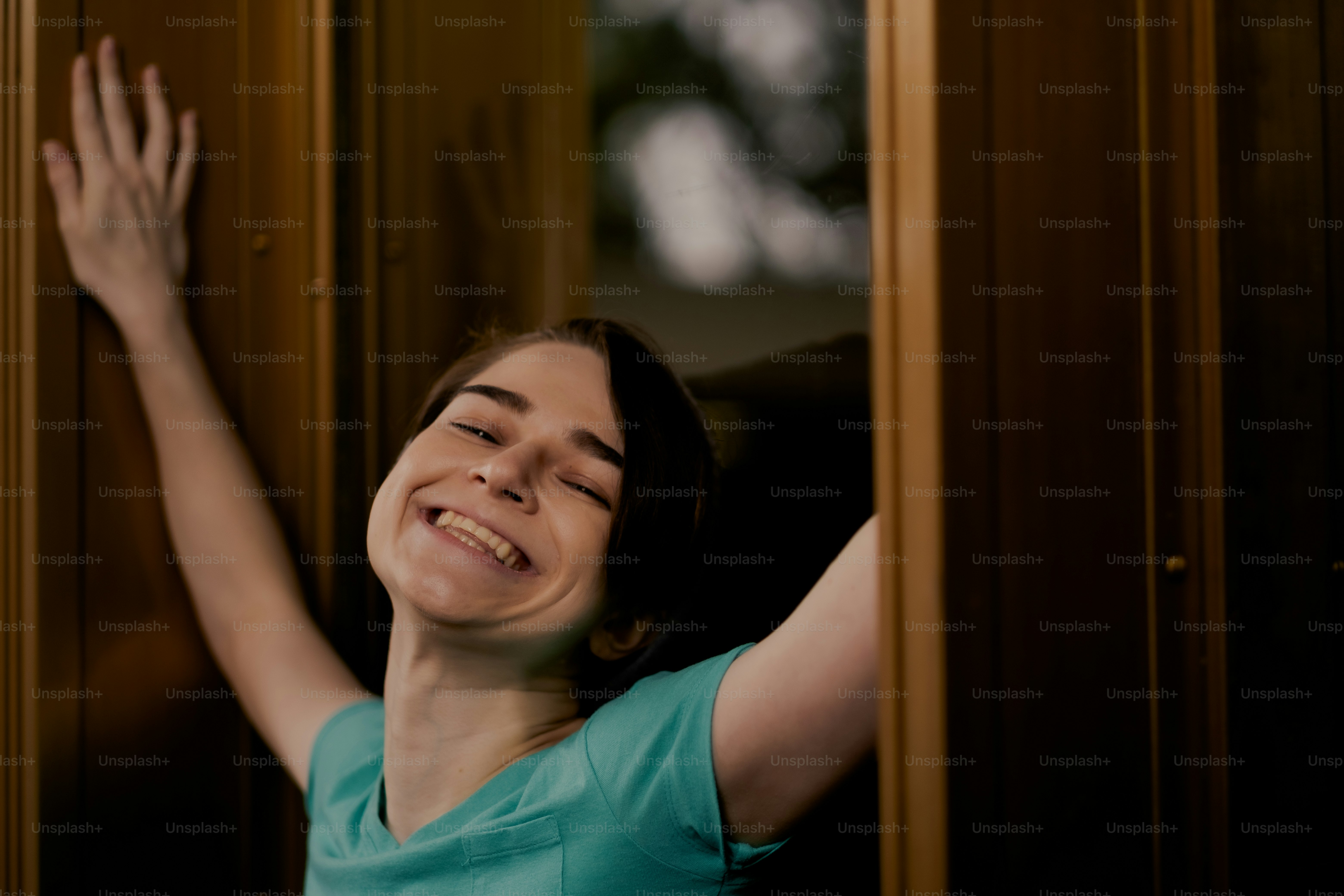 Una mujer está sonriendo y apoyada contra una pared
