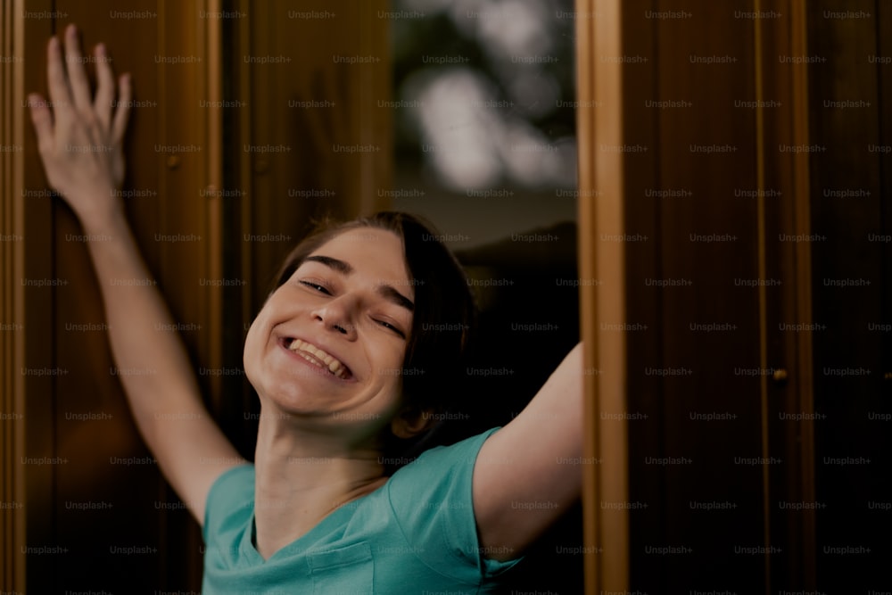 a woman is smiling and leaning against a wall