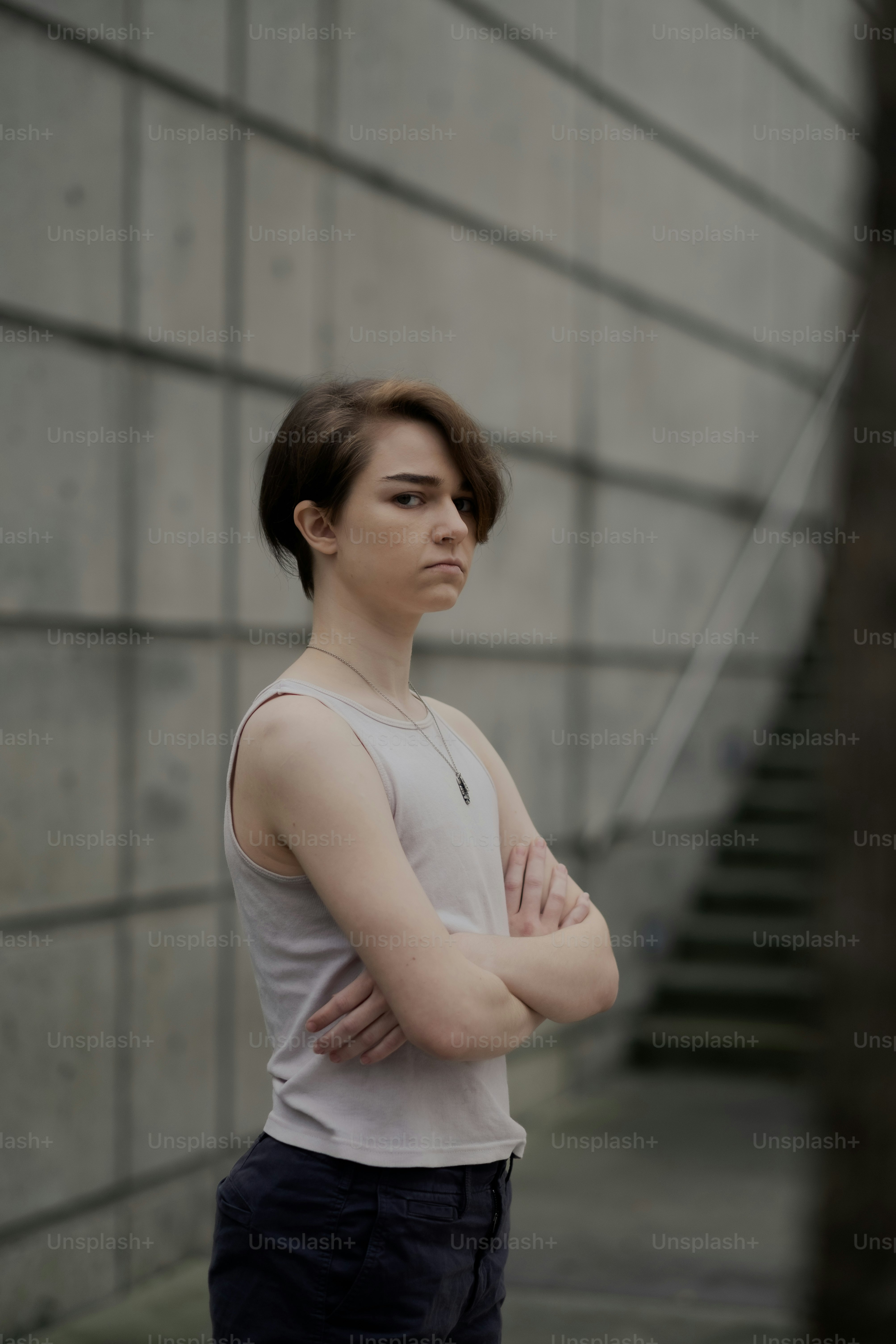 a woman standing in front of a wall with her arms crossed