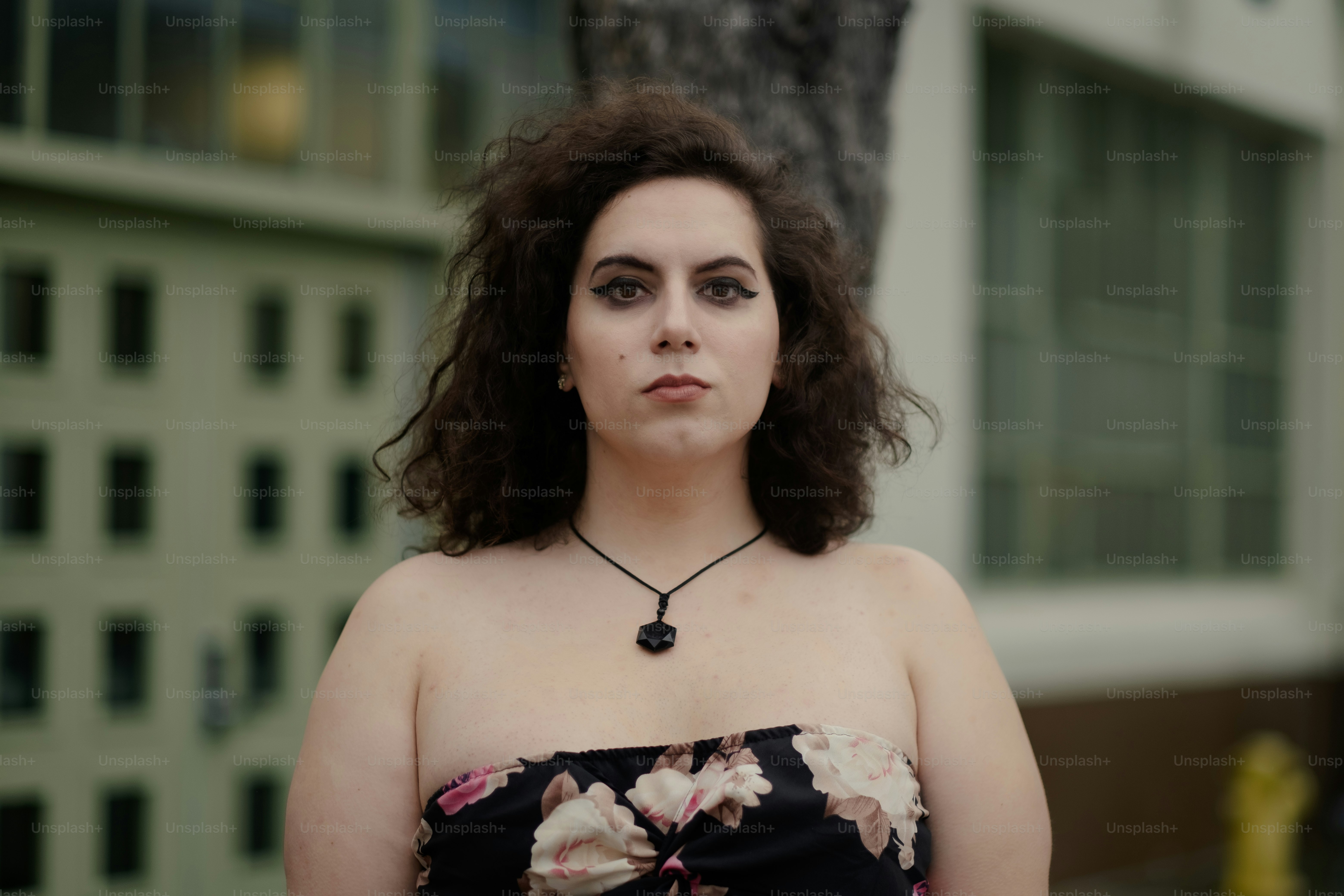 uma mulher em um vestido floral em pé na frente de um edifício