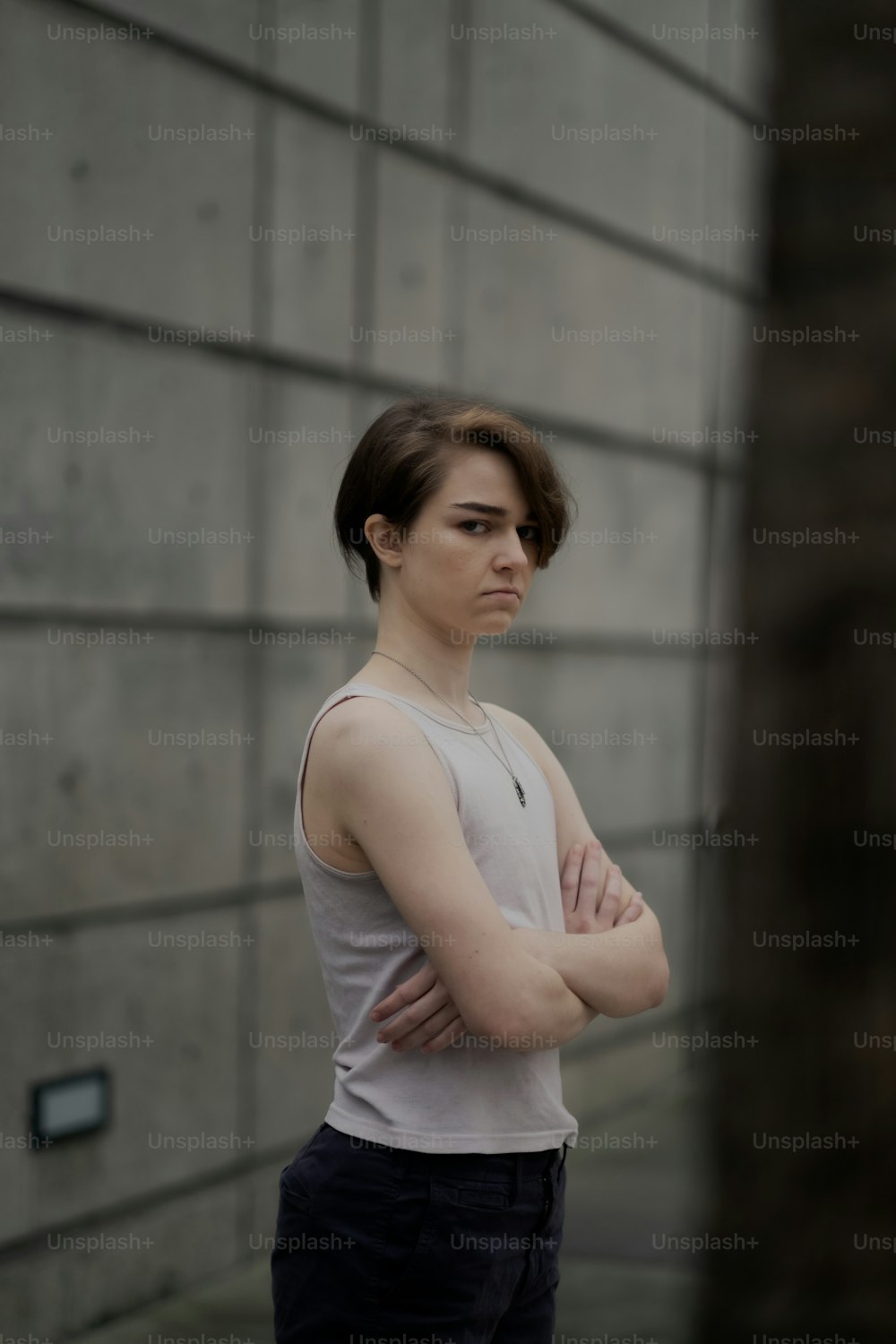 a woman standing in front of a wall with her arms crossed