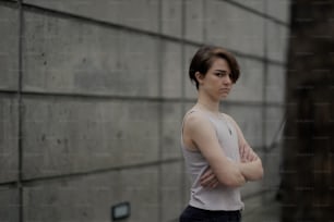 a woman standing in front of a wall with her arms crossed