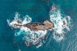 an aerial view of a rock formation in the ocean