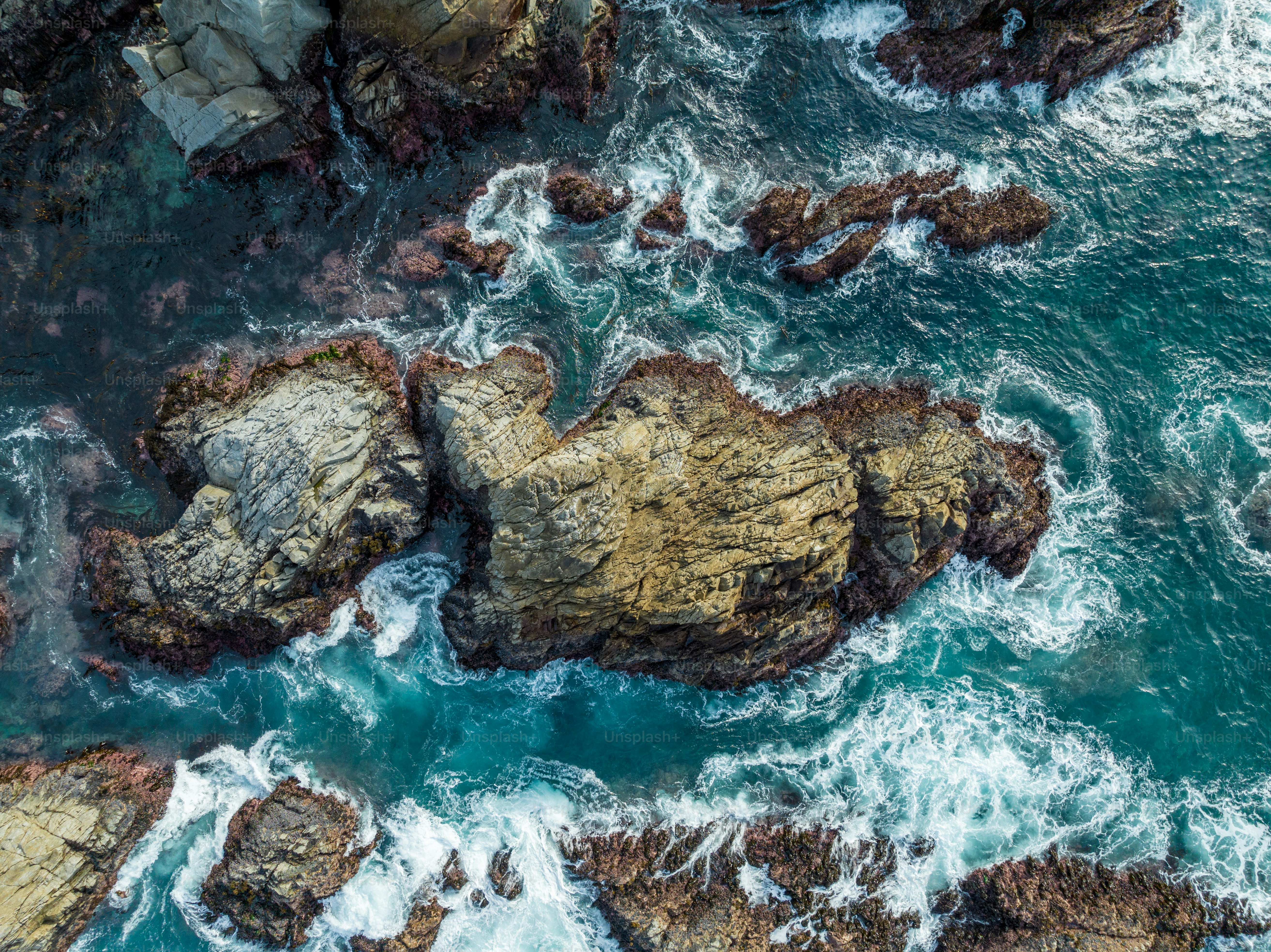 a bird's eye view of the ocean and rocks