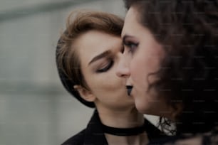 a woman with her eyes closed is kissing another woman