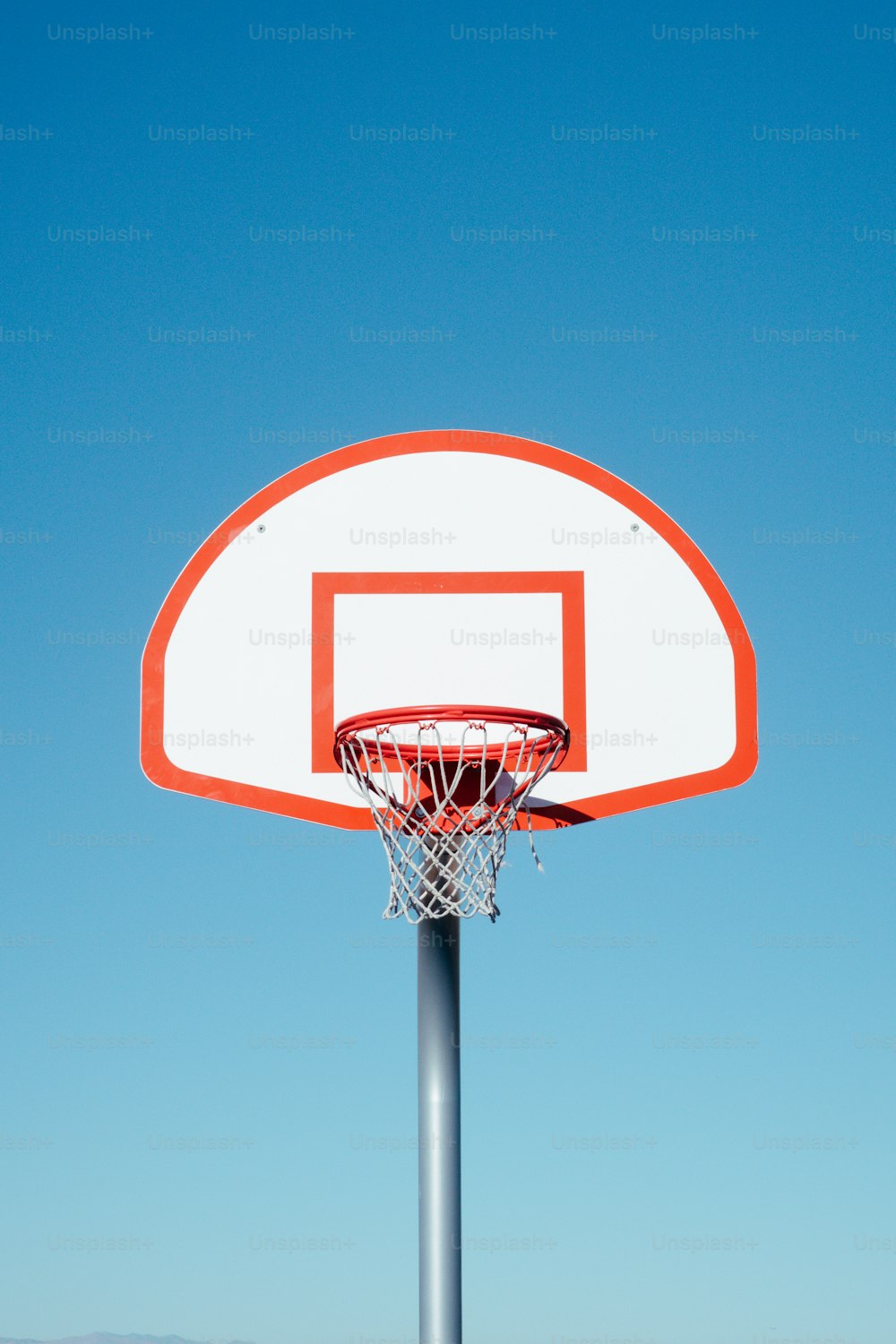 a basketball hoop with a clear blue sky in the background