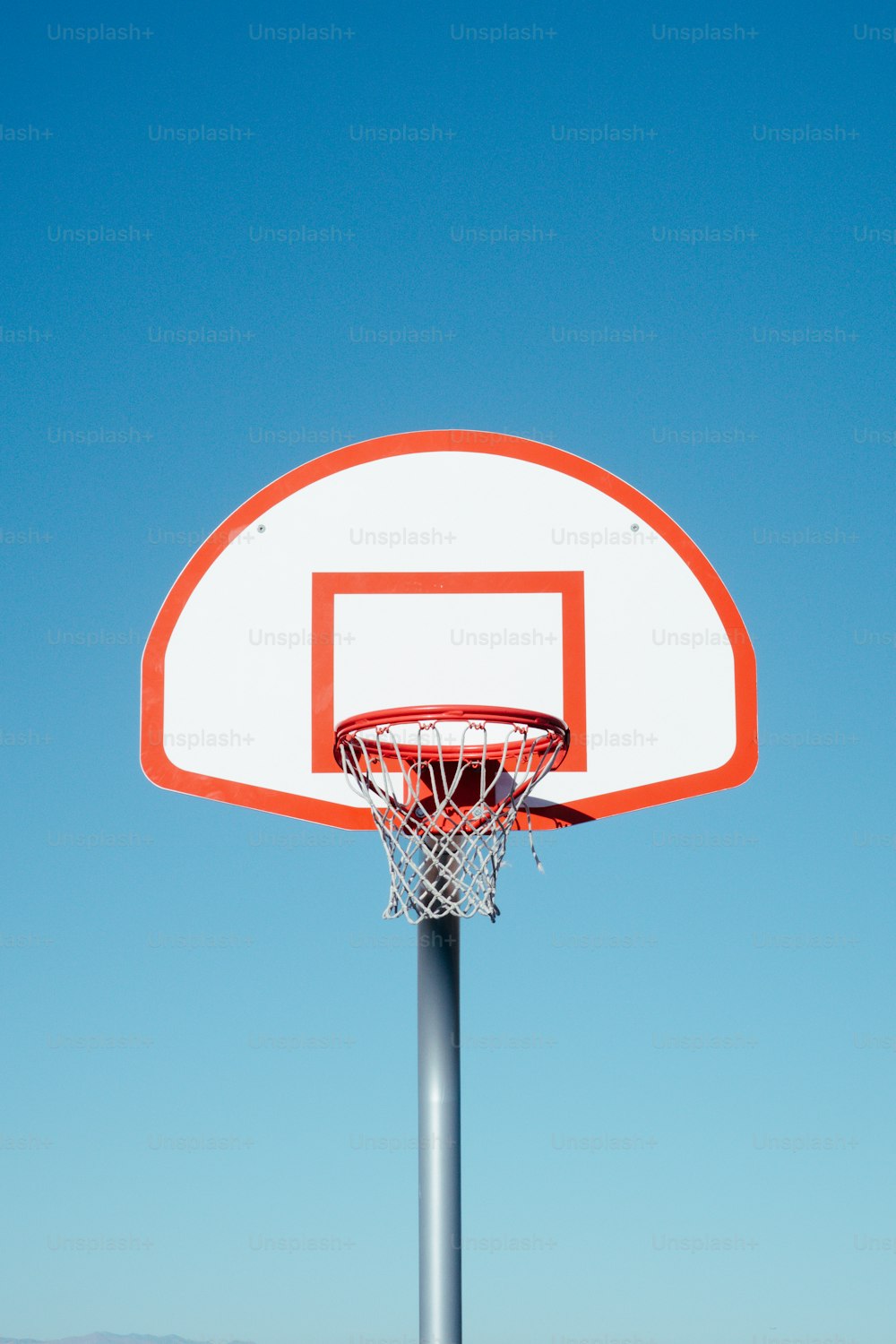 Un aro de baloncesto con un cielo azul claro en el fondo