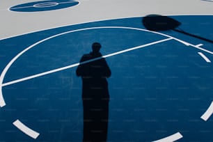 a shadow of a person on a basketball court