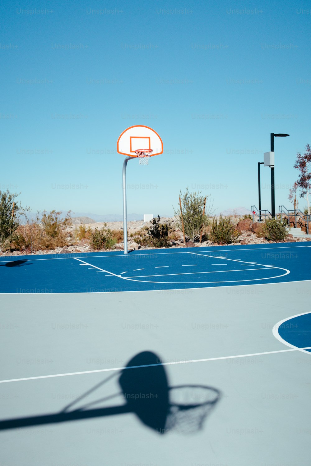 a shadow of a basketball hoop on a basketball court