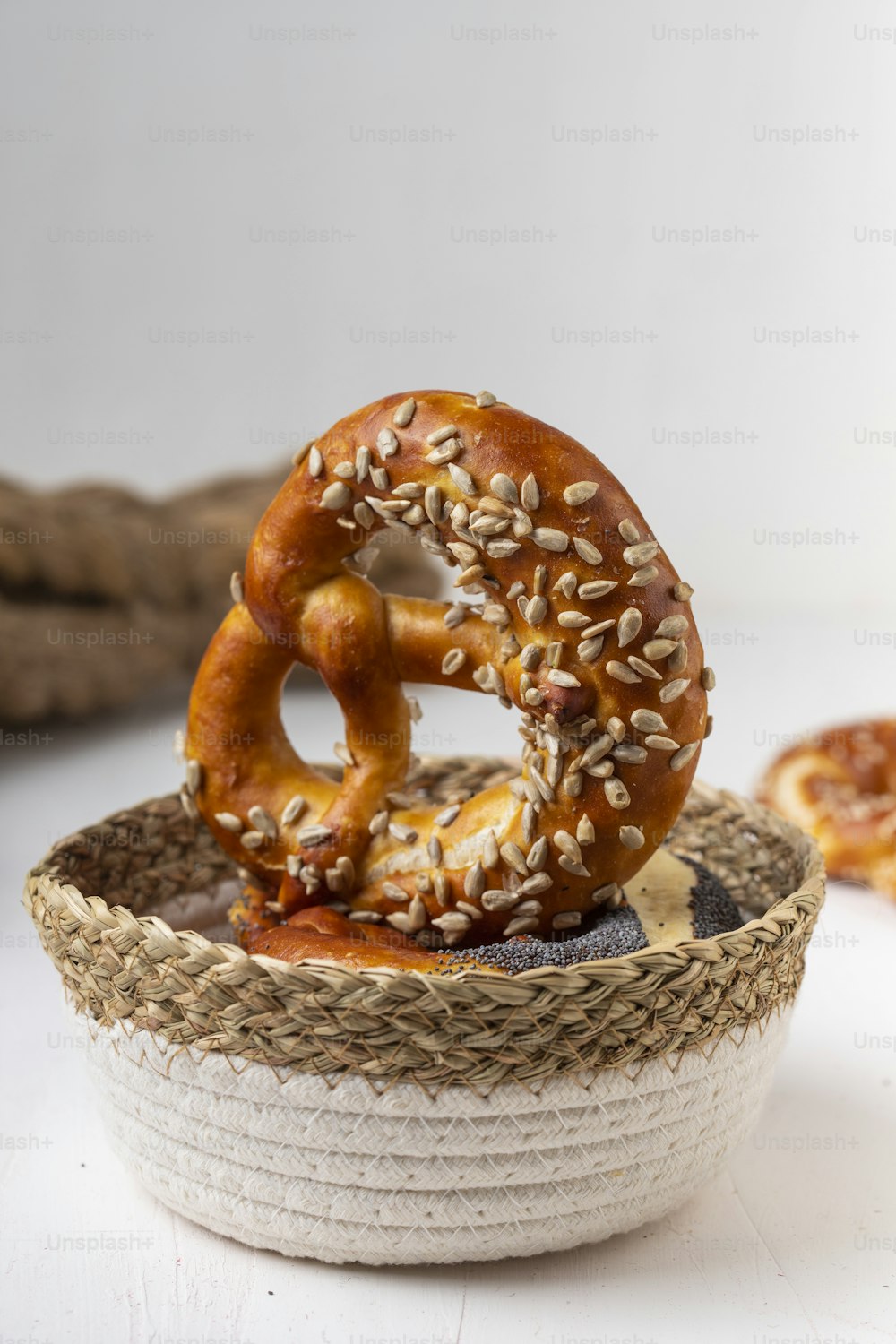 two pretzels in a basket with sesame seeds