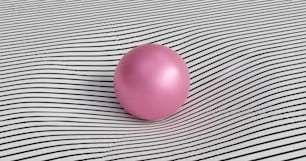 Un globo rosa sentado encima de una superficie a rayas blancas y negras